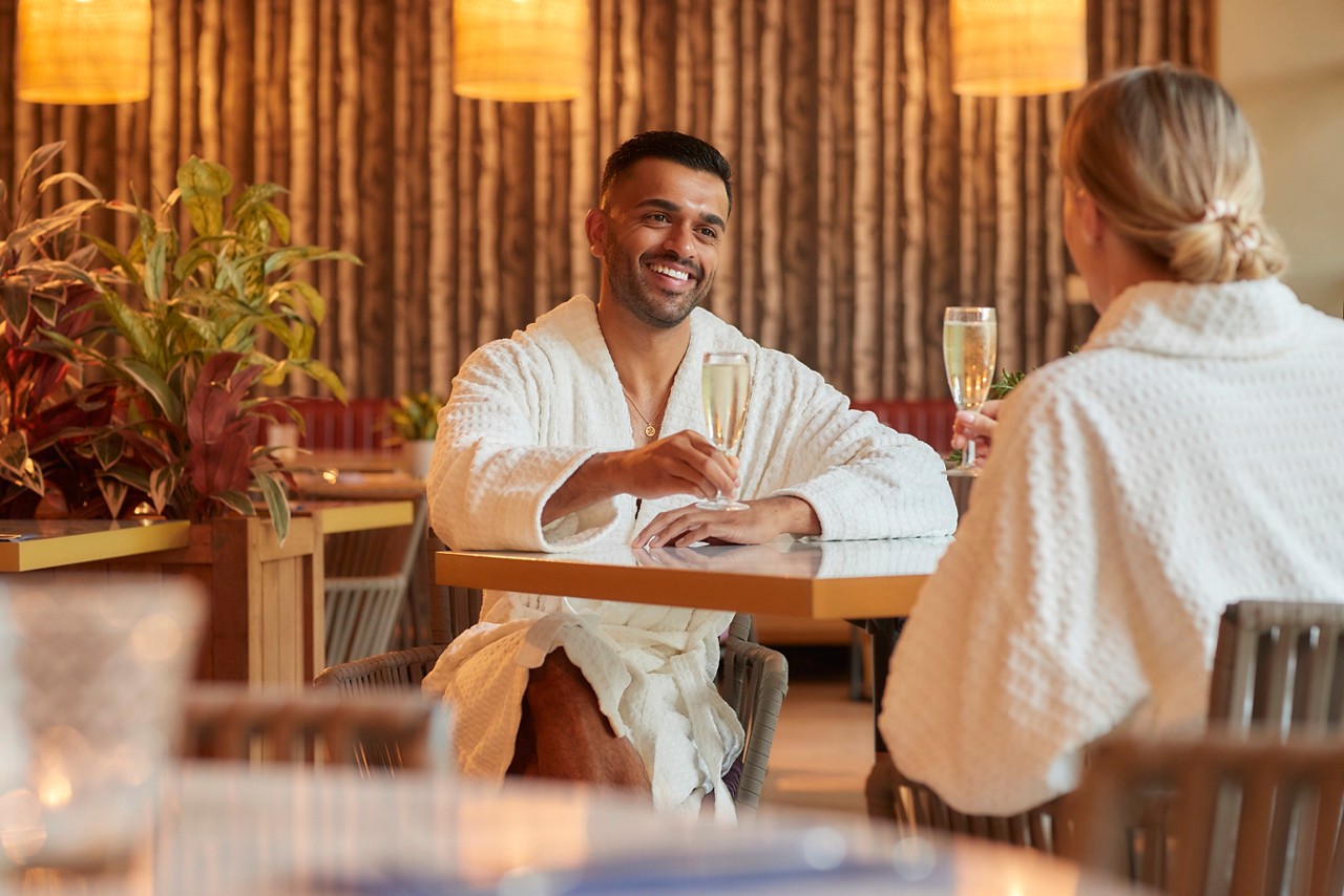 Couple sitting at a table in the Vitalé Café Bar enjoying drinks and dessert.